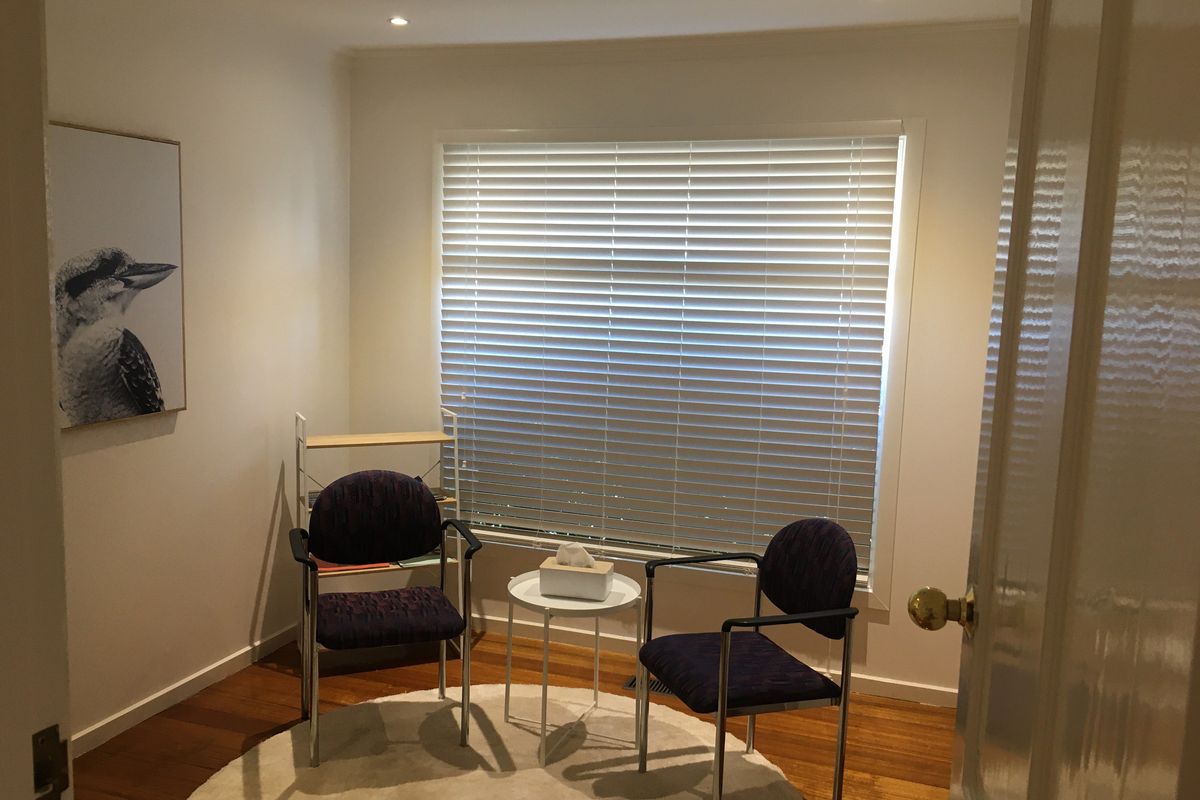 Consult room at Wellbeing Chiropractic Ringwood with two chairs by a window